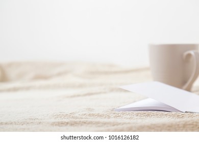 Book And Mug Of Coffee On Soft, Beige Blanket In Bed In The Morning. Enjoying Reading With Coffee Or Tea In Day Off. Resting Time At Home Concept. Empty Place For Text.