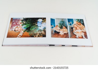 A Book With New Year Photos Of Big Family At Home On A White Background. Photobook Is Gift. Professional Photographer And Designer. Printing Of Photos And Journals In Photo Laboratory