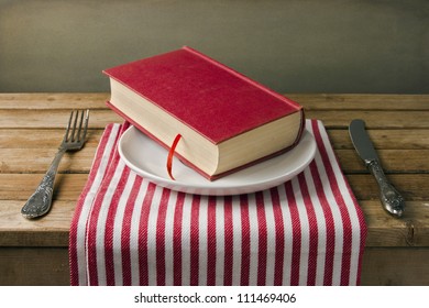 Book On Plate With Knife And Fork. Table Arrangement.