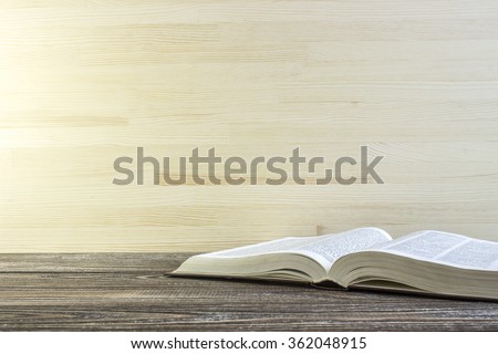 Book on a wooden table. Book is a dictionary. Toned