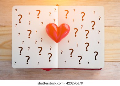 Book With Opened Pages And Clay Heart With Question Mark Symbol Love Concept