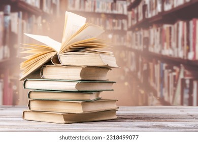 Book with opened pages and stacked books on reading desk in library. National library, books lovers day or month. Back to school or education learning background. Copy space
