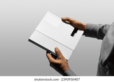 Book and packaging branding mockup template, real photo, man's hand holding branding book package. Blank isolated on a white background to place your design.  - Powered by Shutterstock