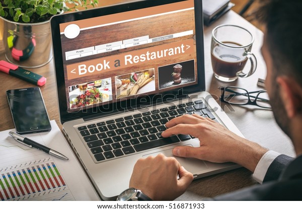 Book a restaurant. Man making an online\
restaurant reservation, office\
background