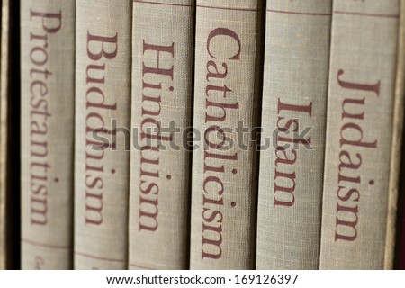 Book spines listing major world religions - Judaism, Islam, Catholicism, Hinduism, Buddhism and Protestantism. The focus is on the word, Catholicism.