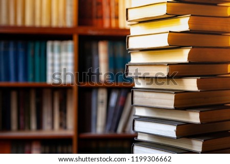 Book stack  blurred bookshelf in the library room, education background, back to school concept