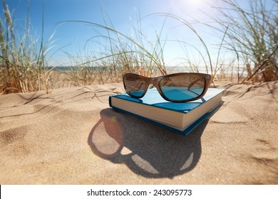 Book and sunglasses on the beach for summer reading and relaxing - Powered by Shutterstock