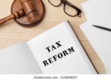 Book With Text TAX REFORM, Gavel And Glasses On Wooden Background, Flat Lay