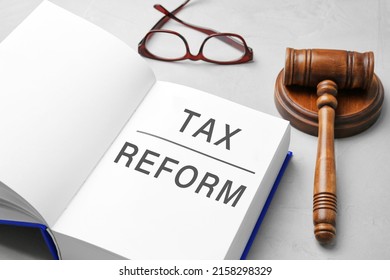 Book With Text TAX REFORM, Gavel And Glasses On Light Grey Table