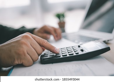 bookkeeper using calculator counting finances taxes fees accounting calculate bills money planning budget loan payment concept pay online on computer do paperwork work at home office desk