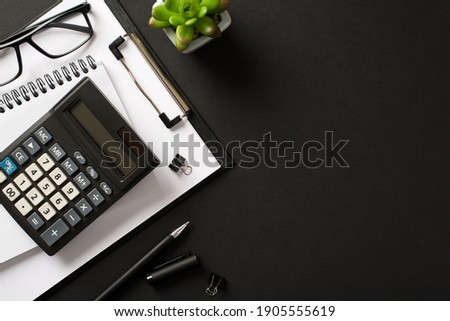 Bookkeepers work place concept. Top above overhead view photo of office accessories calculator pen clipboard notebook isolated black color backdrop with blank empty space