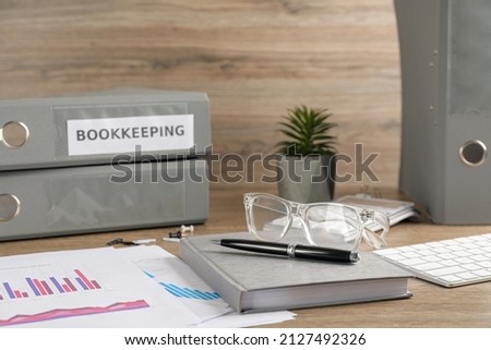 Bookkeeper's workplace with folders and documents on table