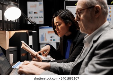 Bookkeeping business executives coworkers imputing administrative analytics data on laptop. Teamworking elderly businessman and asian collegue in accountancy archival depository storage office - Powered by Shutterstock