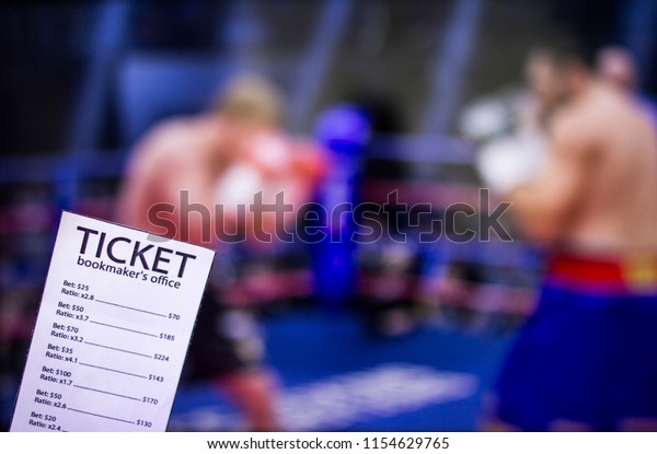 Bookmaker ticket on the background of the\
TV on which show boxing, sports betting,\
ring