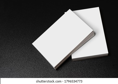 Books with blank cover on dark glossy table, editable mock-up series ready for your design, cover selection path included. 