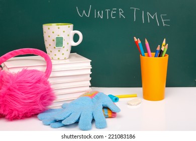 Books , Colored Pencil In Yellow Glass And Winter Gloves On Green Chalkboard. / End Of School. Winter Break