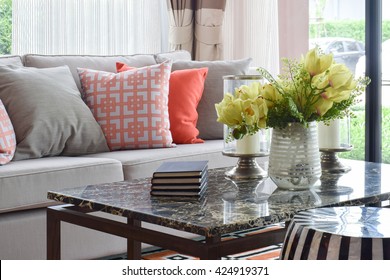 Books and decorative items on marble top table and lively sofa set 