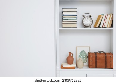 Books and different decorative elements on shelving unit indoors, space for text