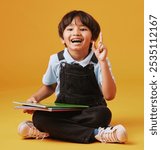 Books, education and child in studio with idea for studying with test, assignment or development. Scholarship, student and Asian kid with learning elementary school for future by yellow background.