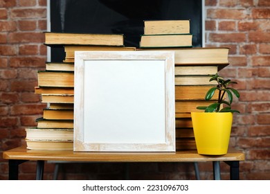 Books and a flower on the background of the school blackboard. Frame for note