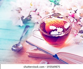 Books, flowers and cup of tea on wooden table - Shutterstock ID 193569875