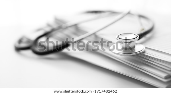 Books folder file with medical data and\
stethoscope isolated on white\
background