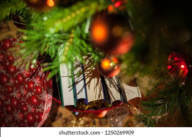 Books In A Gift Box Under A Christmas Tree Decorated With Orange Balls And Garlands