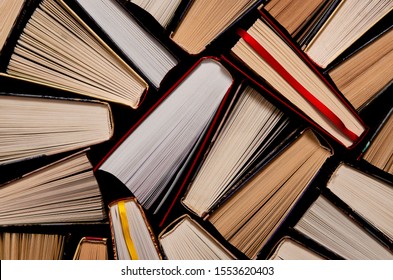 Books. Lots Of Colourful Thick Open Books Stand On A Dark Background