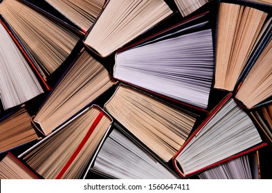 Books. Lots Of Colourful Thick Open Books Stand On A Dark Background