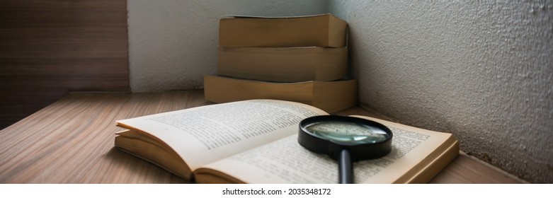 Books And A Magnifier Research Concept. Magnification Glass Over Opened Book