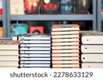 Books, notebooks, notepads lie on bookstore showcase, in library against background of shelves with book
