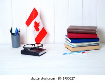 Books, Notebooks, Textbooks, Glasses, A Flag On A Wooden Table. Education In Canada, North America.