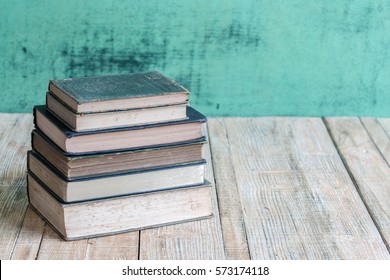Books on the old Wooden table background.