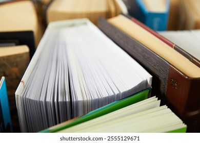 Books opened on the side on the table top view. Colourful book covers and pages texture. Education and business background. Reading hobby, back to school textbook preparations. Book archive details