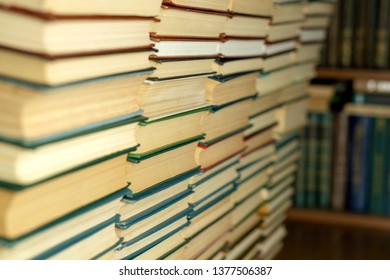 Books in solid overflow on the background of a bookshelf close-up.