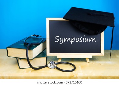 Books, Stethoscope And Blackboard With Text Symposium  On Wooden Background.