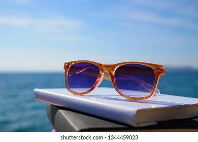 Books and sunglasses by the sea - Powered by Shutterstock