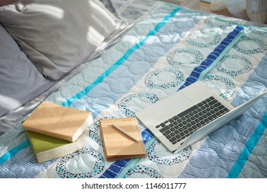 Books, Textbook And Computer On Well Made Bed