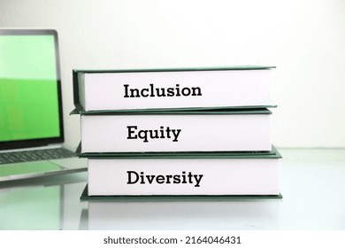 Books With Words DEI, Diversity, Equity, Inclusion On Table With White Background. 