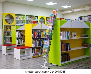 Bookshelf In Library Or Book Store With Many Children Books For Reading Or Sale. Brigth Green Shelves For Fun. Enjoy Kid's Reading Concept. Novosibirsk, Russia - April 1, 2022