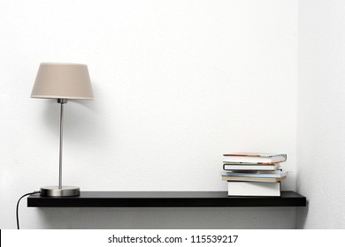 Bookshelf On The Wall With Lamp And Books
