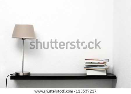 bookshelf on the wall with lamp and books