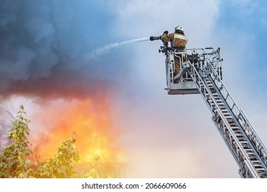 Boom Crane With Firefighters. Man Firefighter Retractable Crane. Extinguishing Flame From Height. Firefighter Extinguishes Fire. Extinguishing Forest Fires. Fire Fighter Directed Hose Towards Trees