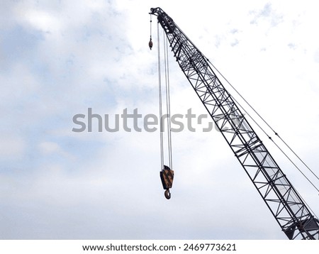 Image, Stock Photo The crane has a heavy load on the hook.