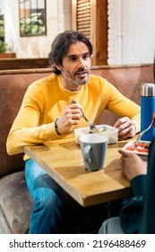 Boomer Man Eating Lunch With His Coworkers In The Office Kitchen And Talking. Co-working Concept.