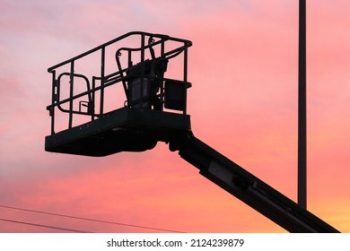 Boom-Lift Basket Silhouette With Orange Sky