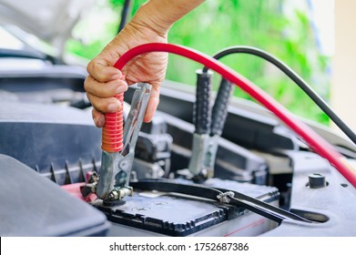 The booster cables and discharged battery, Charging car battery with electricity trough jumper cables