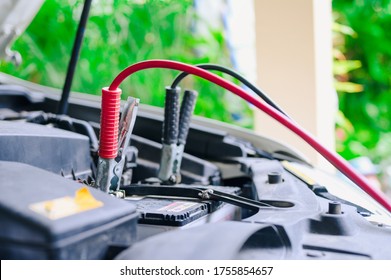 The booster cables and discharged battery, Charging car battery with electricity trough jumper cables - Powered by Shutterstock