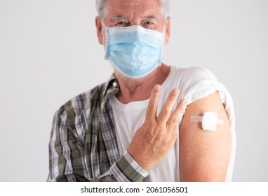 Booster coronavirus. Portrait of old caucasian senior man patient wearing face mask showing with fingers number three as third doses of covid-19 coronavirus vaccine, looking at camera - Shutterstock ID 2061056501
