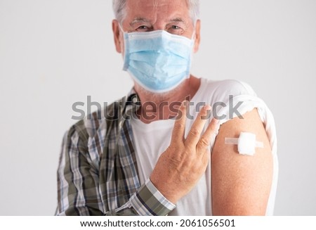 Booster coronavirus. Portrait of old caucasian senior man patient wearing face mask showing with fingers number three as third doses of covid-19 coronavirus vaccine, looking at camera